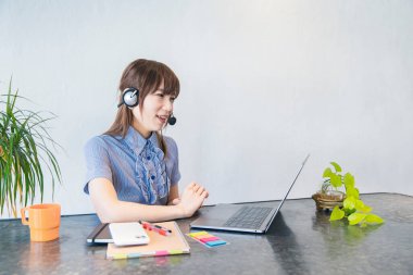 Asyalı kadın iş adamı internet ve dizüstü bilgisayarla iletişim kuruyor