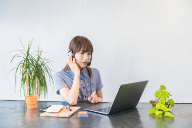 Asyalı kadın iş adamı internet ve dizüstü bilgisayarla iletişim kuruyor