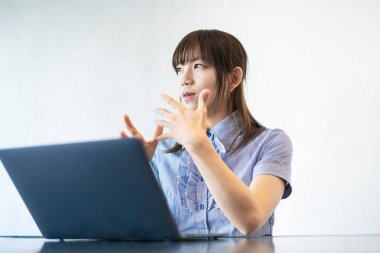 Asyalı kadın iş adamı internet ve dizüstü bilgisayarla iletişim kuruyor