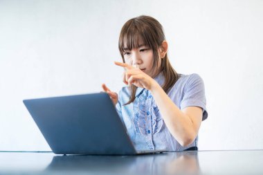 Asyalı kadın iş adamı internet ve dizüstü bilgisayarla iletişim kuruyor