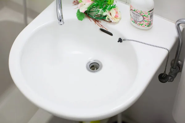 A clean washroom and a white washbasin in a house