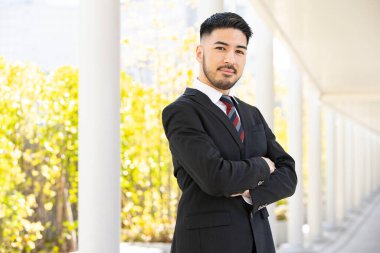 Açık havada duran, sakallı, melez, genç bir iş adamı.