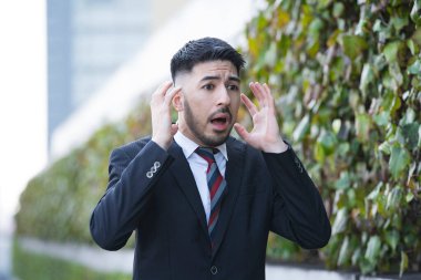 Takım elbiseli, sakallı, melez bir iş adamı şok oldu.