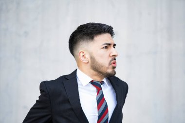 Takım elbiseli, sakallı genç iş adamı umutsuzluk içinde bağırıyor.