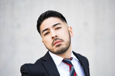 Karışık ırk genç işadamı, takım elbiseli, tüyler ürpertici bir gülümseme.