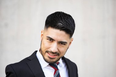 Karışık ırk genç işadamı, takım elbiseli, tüyler ürpertici bir gülümseme.