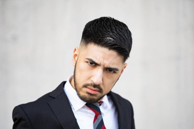 Karışık ırk genç işadamı, takım elbiseli, tüyler ürpertici bir gülümseme.