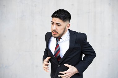 Takım elbiseli, sakallı genç iş adamı umutsuzluk içinde bağırıyor.