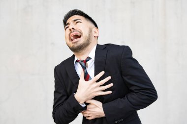 Takım elbiseli, sakallı genç iş adamı umutsuzluk içinde bağırıyor.