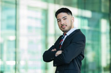 Açık havada duran, sakallı, melez, genç bir iş adamı.