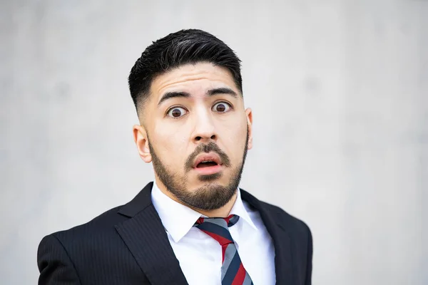 Mixed race young businessman with beard in suit screaming in despair