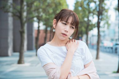 Asyalı kadın sert omuzlar ve boyun ağrısı çekiyor.