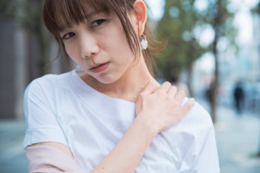 Asyalı kadın sert omuzlar ve boyun ağrısı çekiyor.