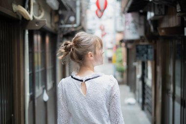Tokyo 'da içki içilen bir yerde duran beyaz bir kadın.