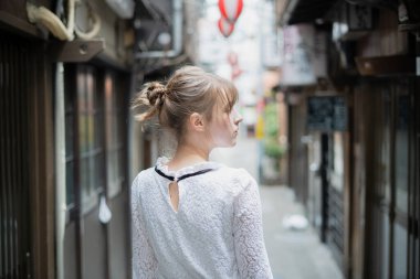 Tokyo 'da içki içilen bir yerde duran beyaz bir kadın.