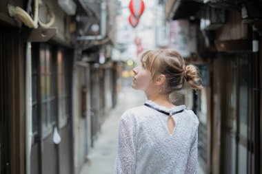 Tokyo 'da içki içilen bir yerde duran beyaz bir kadın.