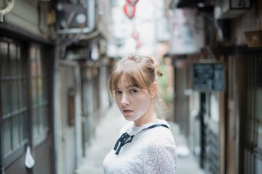 Tokyo 'da içki içilen bir yerde duran beyaz bir kadın.