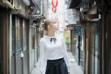Tokyo 'da içki içilen bir yerde duran beyaz bir kadın.