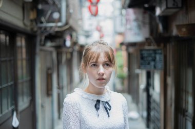 Tokyo 'da içki içilen bir yerde duran beyaz bir kadın.