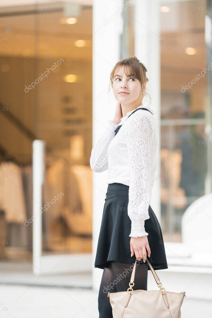 Caucasian young woman walking on a shopping street in Shibuya, Tokyo