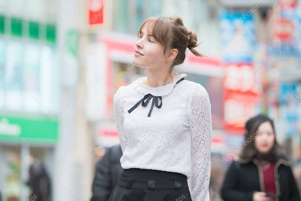 Young European woman sightseeing downtown Shibuya (Tokyo, Japan) with a smile