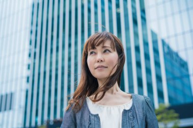 Güneşli bir günde açık havada gülümseyen Asyalı (Japon) iş kadınının portresi