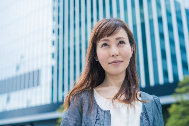 Güneşli bir günde açık havada gülümseyen Asyalı (Japon) iş kadınının portresi
