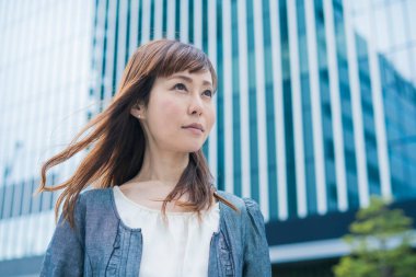 Güneşli bir günde açık havada gülümseyen Asyalı (Japon) iş kadınının portresi