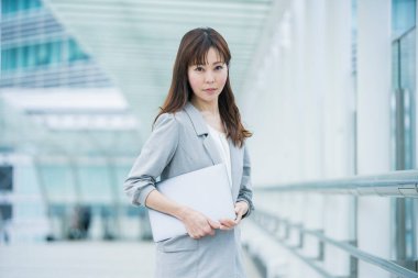 Asyalı (Japonca) kadın ofis çalışanı dışarıda dizüstü bilgisayarla çalışıyor