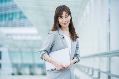 Asyalı (Japonca) kadın ofis çalışanı dışarıda dizüstü bilgisayarla çalışıyor
