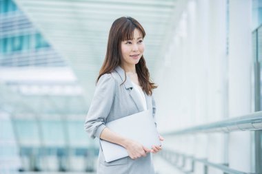 Asyalı (Japonca) kadın ofis çalışanı dışarıda dizüstü bilgisayarla çalışıyor