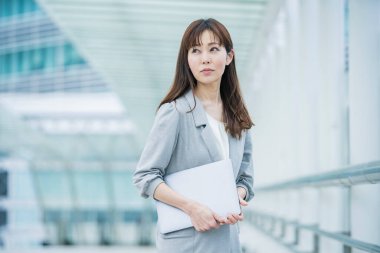Asyalı (Japonca) kadın ofis çalışanı dışarıda dizüstü bilgisayarla çalışıyor