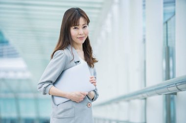 Asyalı (Japonca) kadın ofis çalışanı dışarıda dizüstü bilgisayarla çalışıyor
