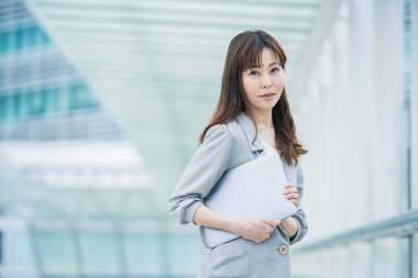 Asyalı (Japonca) kadın ofis çalışanı dışarıda dizüstü bilgisayarla çalışıyor