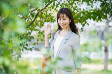 Asyalı iş kadını iş yerine günlük kıyafetlerle gidip geliyor.