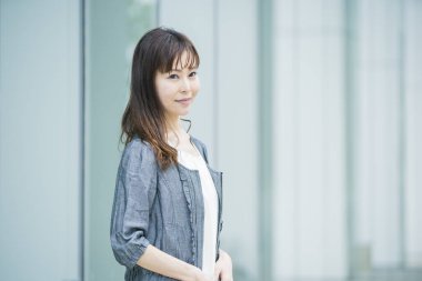 Güneşli bir günde açık havada gülümseyen Asyalı (Japon) iş kadınının portresi