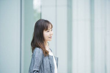 Güneşli bir günde açık havada gülümseyen Asyalı (Japon) iş kadınının portresi