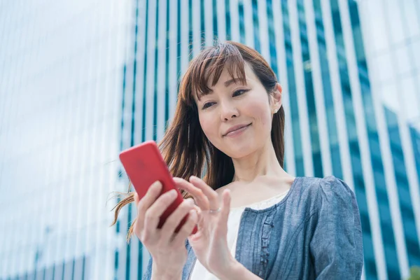 スマートフォンを使って写真を撮り アプリを使ってアジアのビジネス女性 — ストック写真