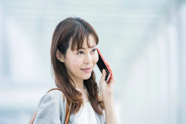 Asian female business person contacting using a smartphone at outdoors