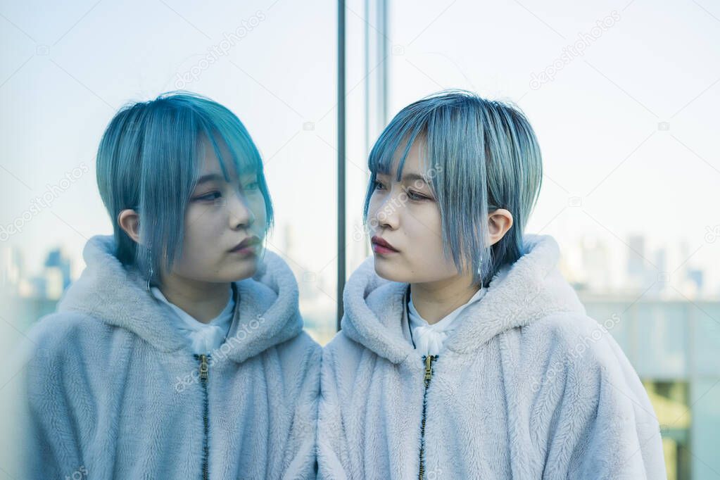 Young Asian (Japanese) woman with blue hair and her reflection