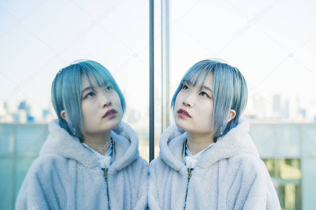 Young Asian (Japanese) woman with blue hair and her reflection