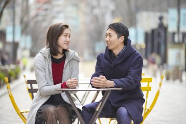 Asyalı (Japonca) genç aşıklar dışarıda konuşuyorlar ve gülüyorlar ve samimi olarak.