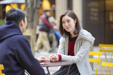 Asyalı (Japonca) genç aşıklar dışarıda konuşuyorlar ve gülüyorlar ve samimi olarak.