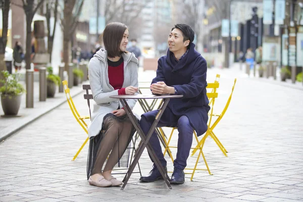 アジア系 日本人 の若い恋人が屋外で話して笑顔で親密に — ストック写真