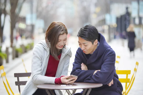 연인들이 웃으며 스마트폰을 친밀하게 바라본다 — 스톡 사진