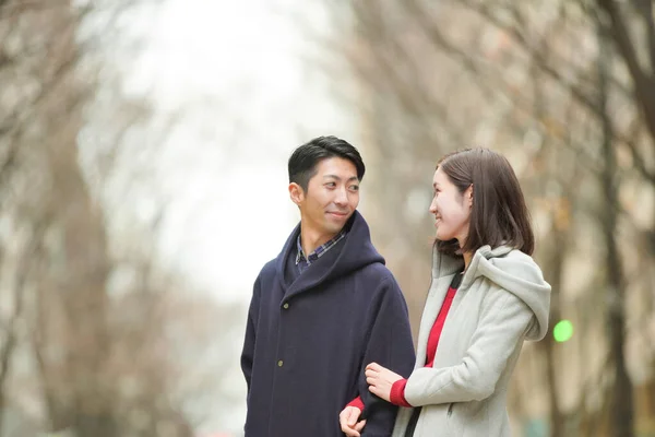 アジア系 日本人 の若い恋人が屋外で話して笑顔で親密に — ストック写真