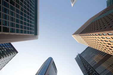 Bulutsuz güneşli bir günde iş bölgesindeki gökdelenlere bakıyorum.