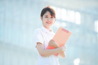 Açık havada gülümseyen Asyalı (Japon) kadın hemşire portresi