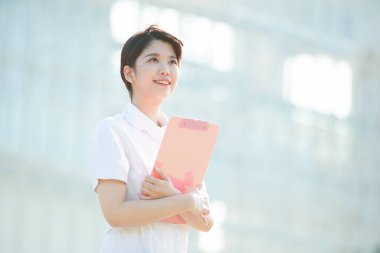 Açık havada gülümseyen Asyalı (Japon) kadın hemşire portresi