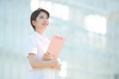 Açık havada gülümseyen Asyalı (Japon) kadın hemşire portresi